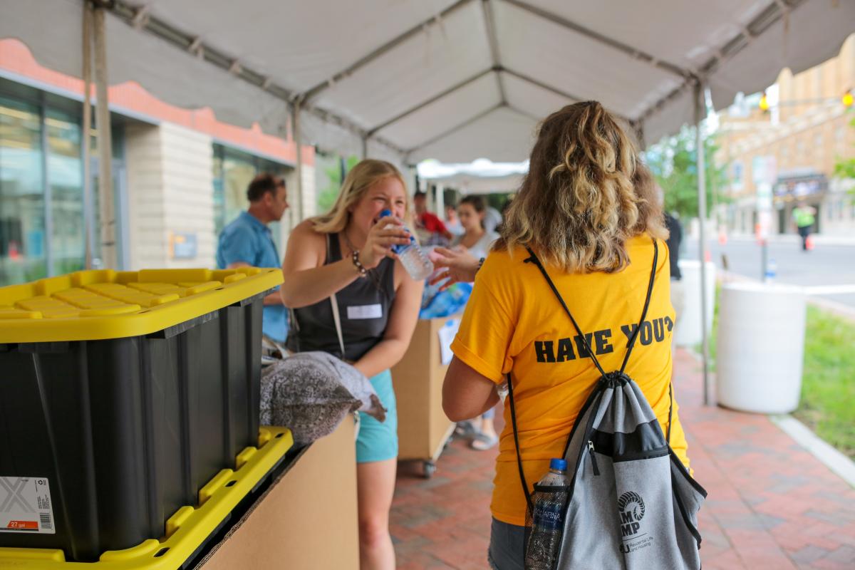 Ariel Moore passes out water in front of Gladding Residence Center during freshman move-in on Saturday. Photo by Jon Mirador