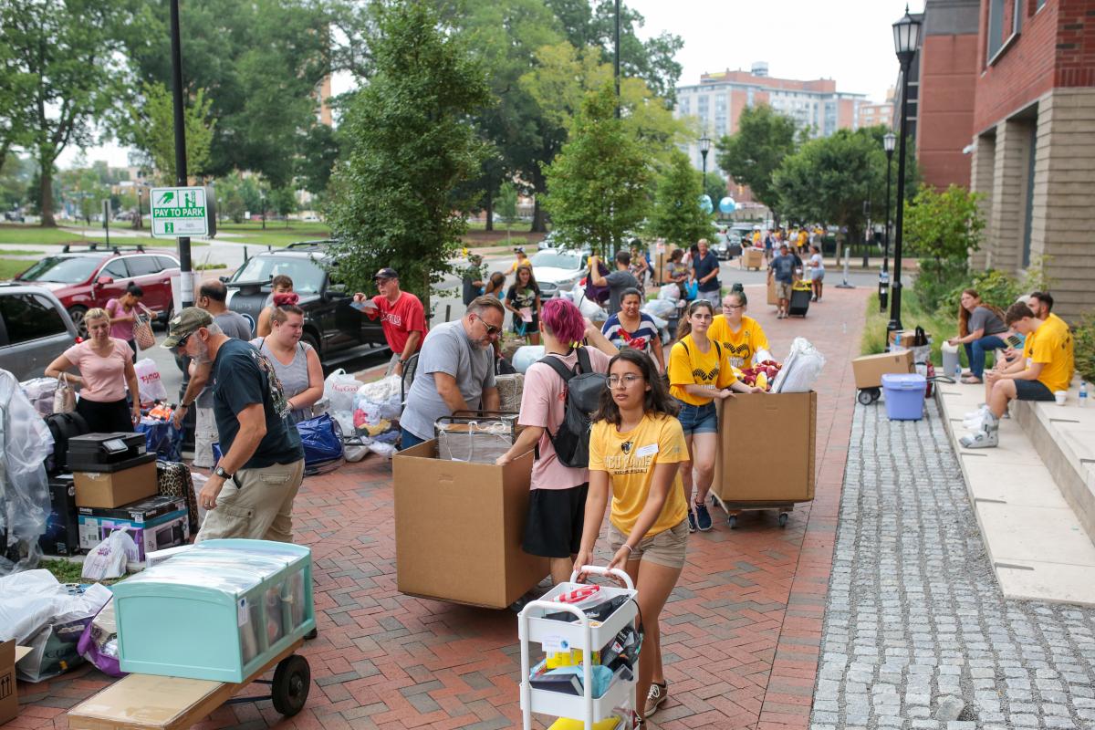 Volunteers, students and family members wait outside Gladding Residence Center on move-in day on Saturday. 