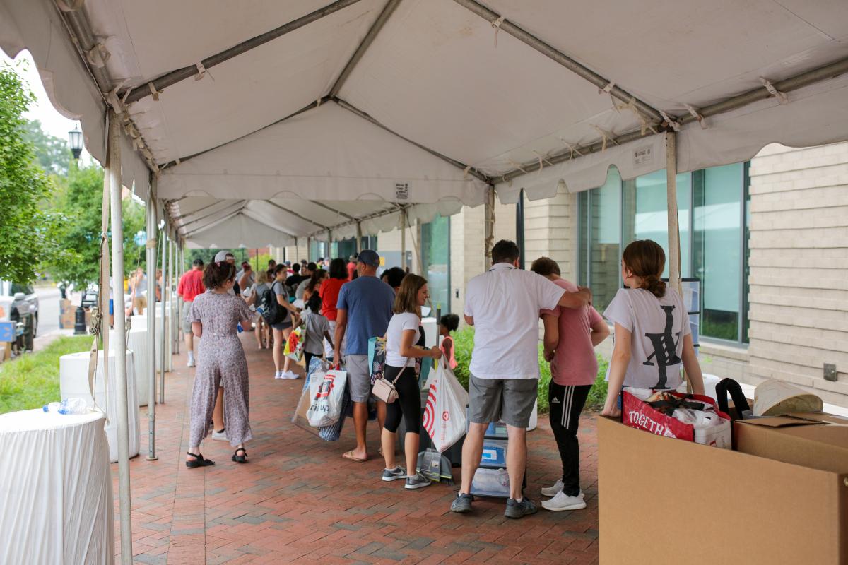 Students and family members line up under a tent outside Gladding Residence Center. 